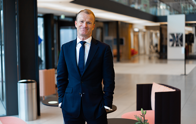 Man i kostym står i ett modernt kontorsutrymme
