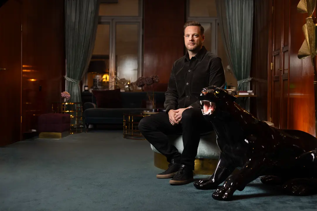 Man sitter i stilfullt inredd salong med glänsande svart panterstaty